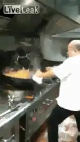 Chef Cooking with Wok in Kitchen